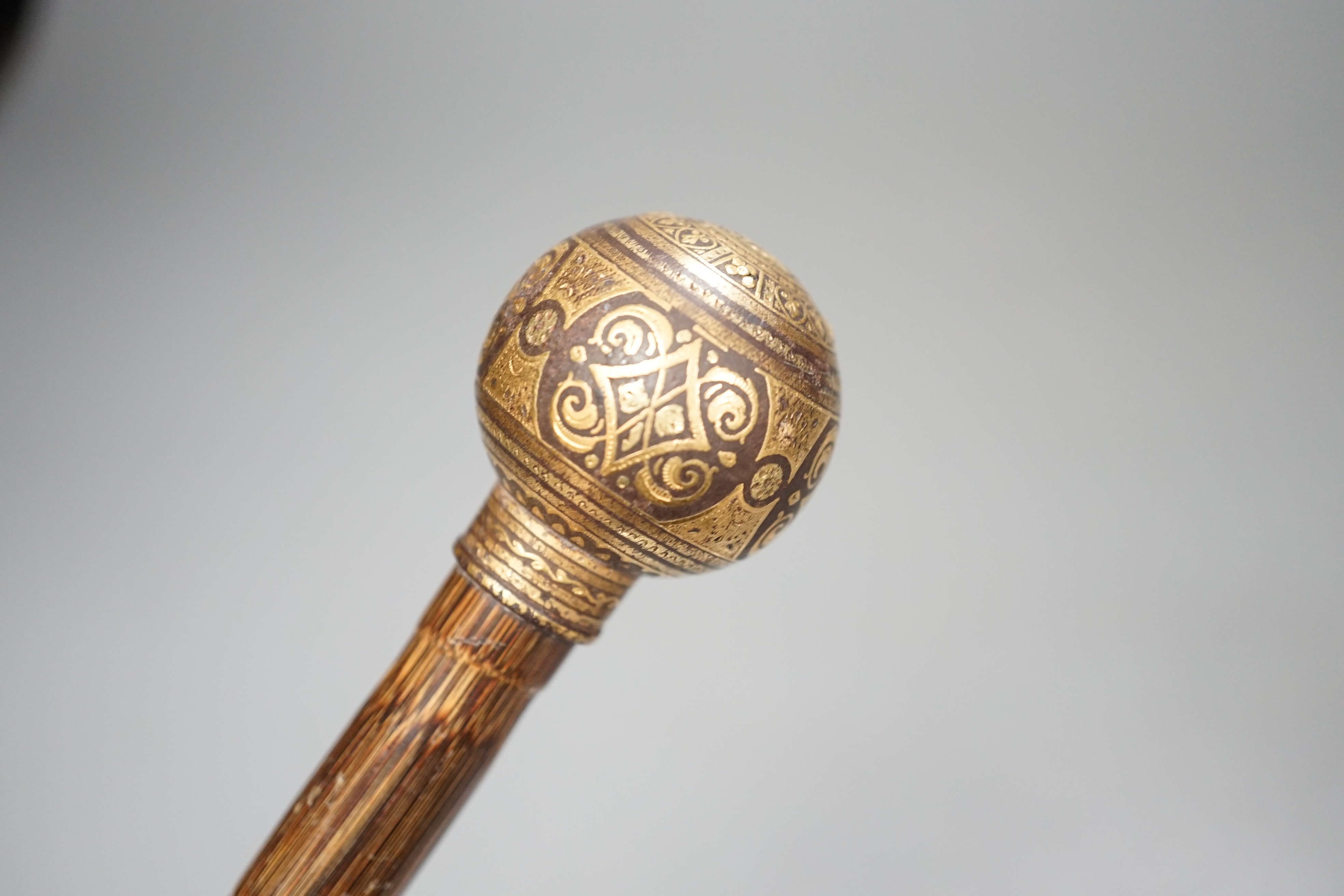 An early 20th century ivory ‘sphinx’ parasol handle, 84cm, together with another gold and iron damascened parasol handle, 62cm